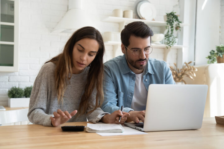 Serious,Man,And,Woman,Calculating,Bills,,Using,Calculator,And,Laptop,