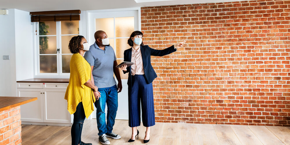 Real,Estate,Agent,And,Customer,In,Face,Mask,Looking,At