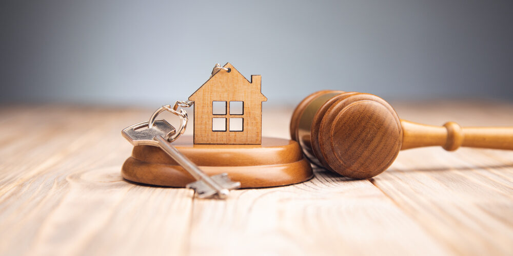 Judge,Gavel,And,House,Key,On,Wooden,Background.,Estate,Law