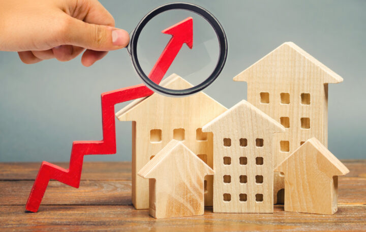Miniature,Wooden,Houses,And,Red,Arrow,Up.,The,Concept,Of