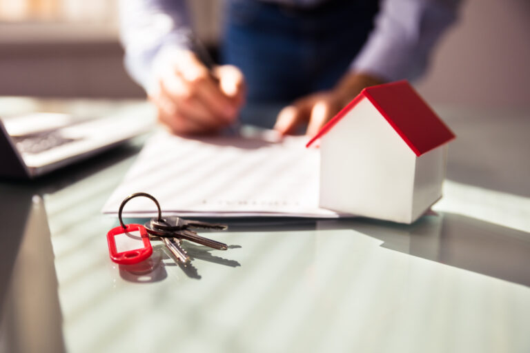 Close-up,Of,House,Model,And,Key,Near,Human,Hand,Signing