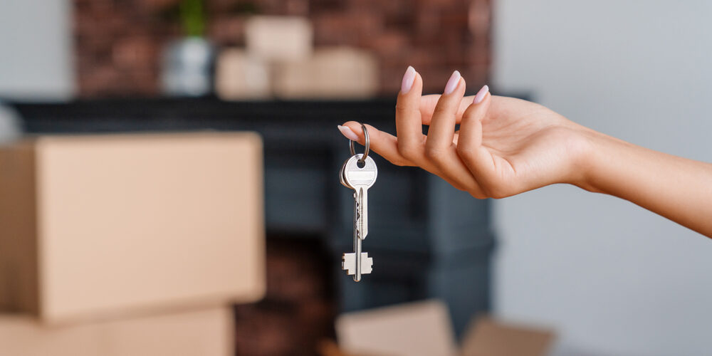 House,Key,In,Womans,Hands,,Concept,Of,Moving,Or,Rent